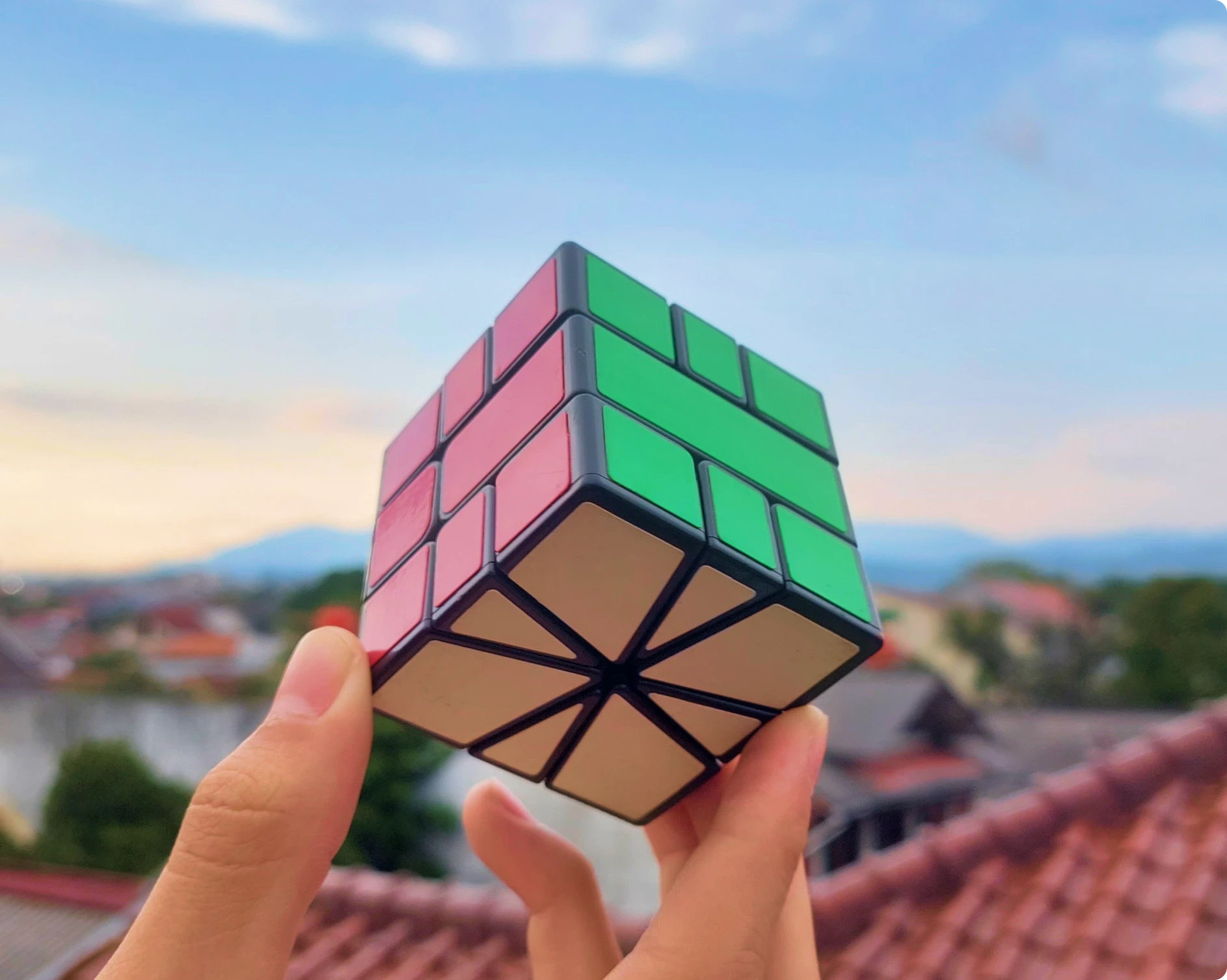 Hands holding a Rubik's cube rooftop view